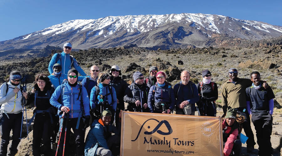 Marangu Route: Climbers celebrating at the highest point in Africa on Mount Kilimanjaro.